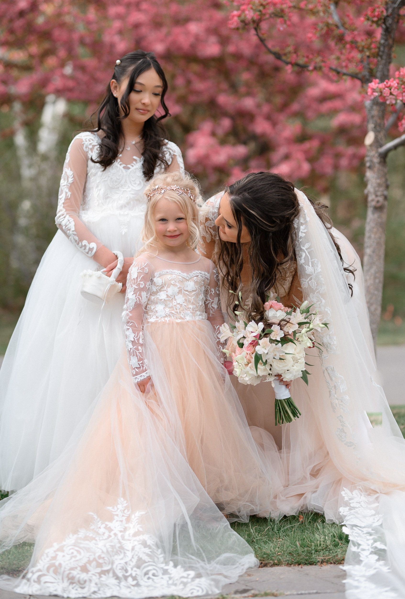 Three bridesmaids and a little girl in wedding dresses.