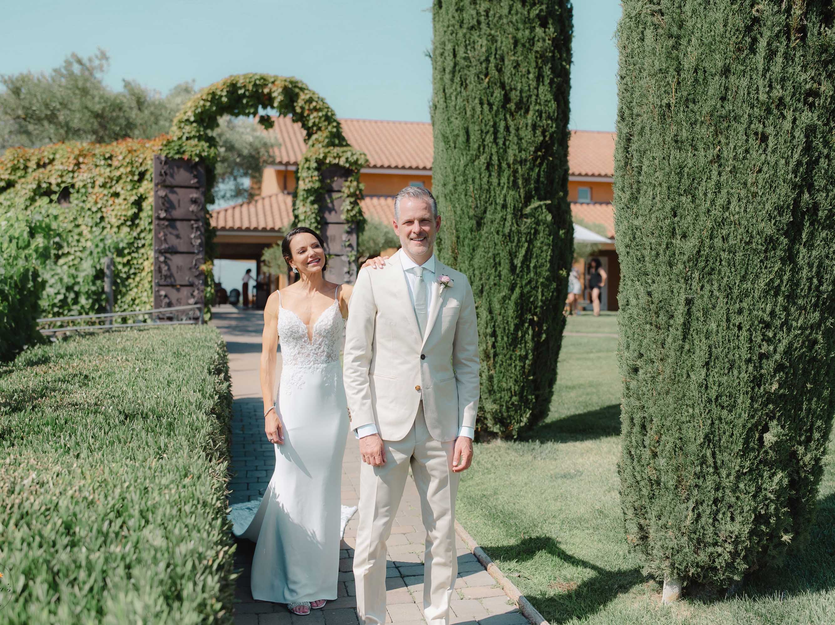 A bride and groom standing in front of a grove of cypress trees.