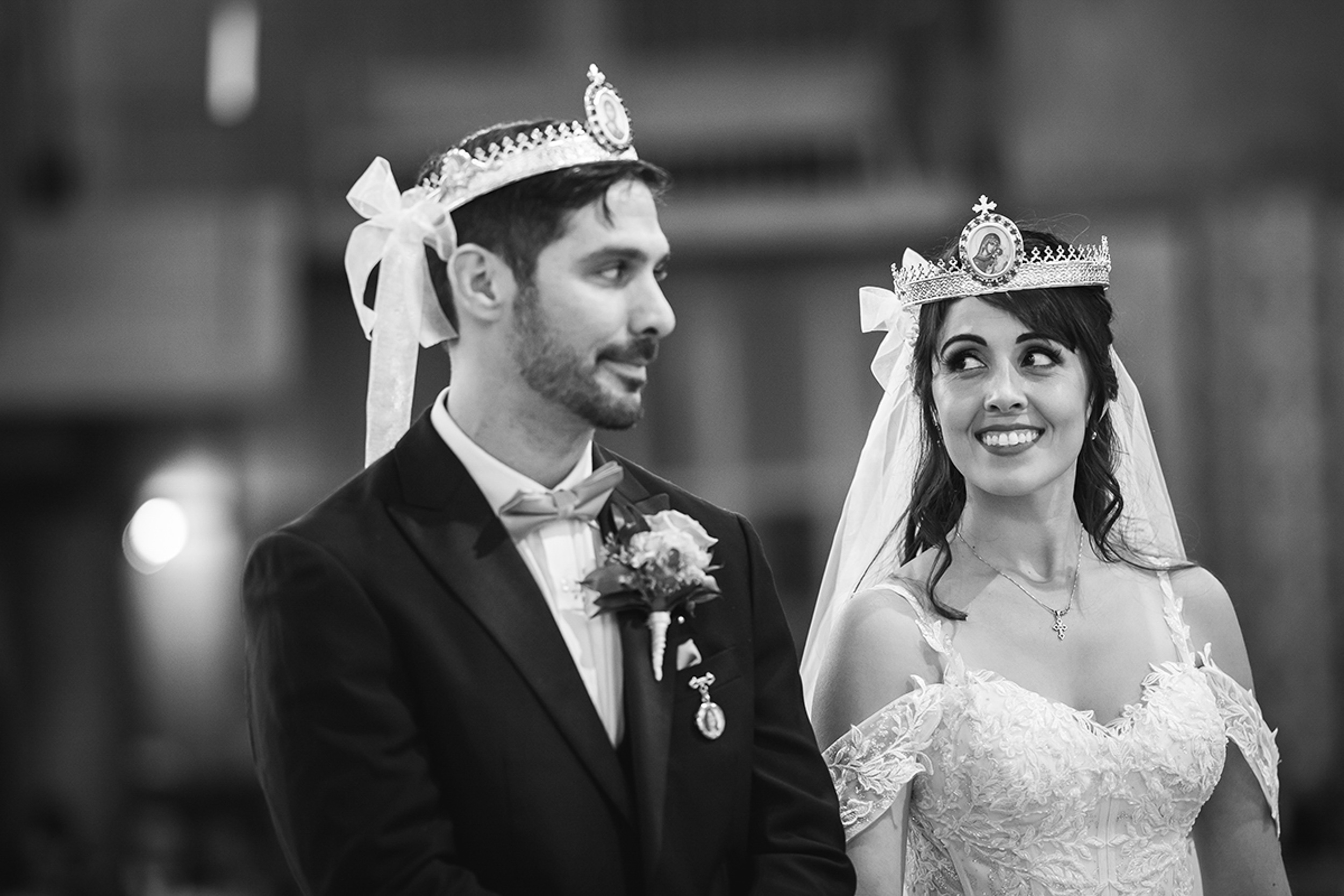 A bride and groom wearing tiaras during their wedding ceremony.