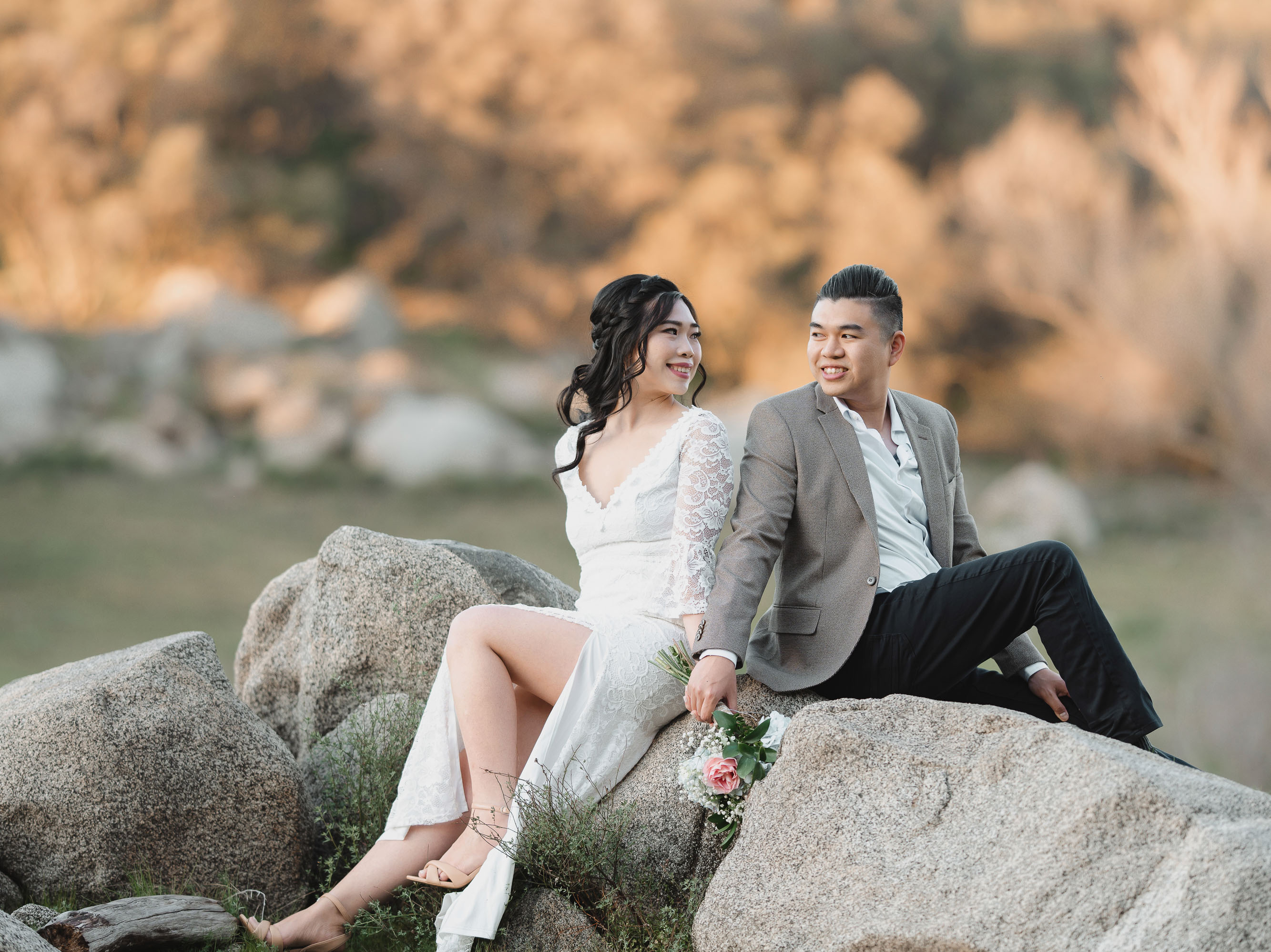 A bride and groom sitting on rocks during their elopement.